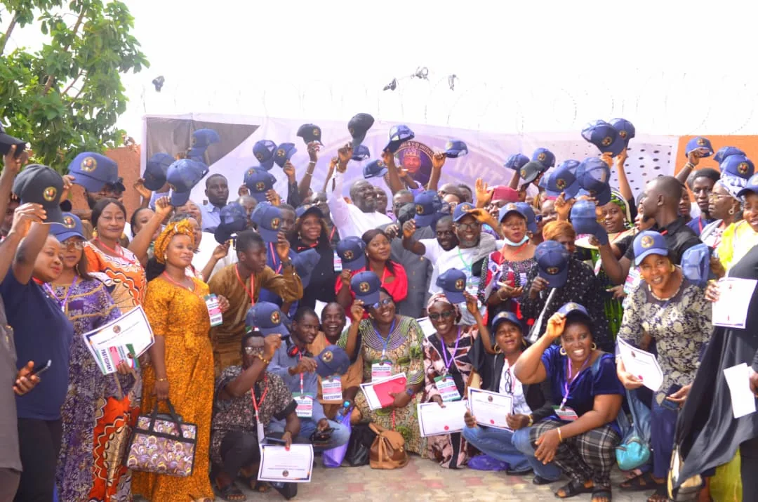 A large cohort celebrating with certificates and programme caps