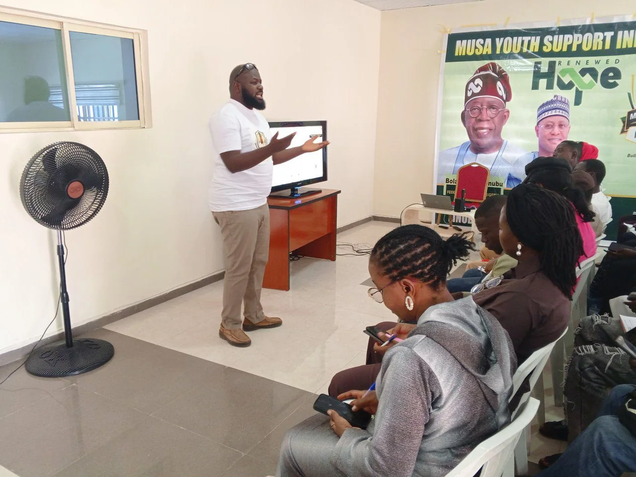 A facilitator teaching participants beside a presentation screen